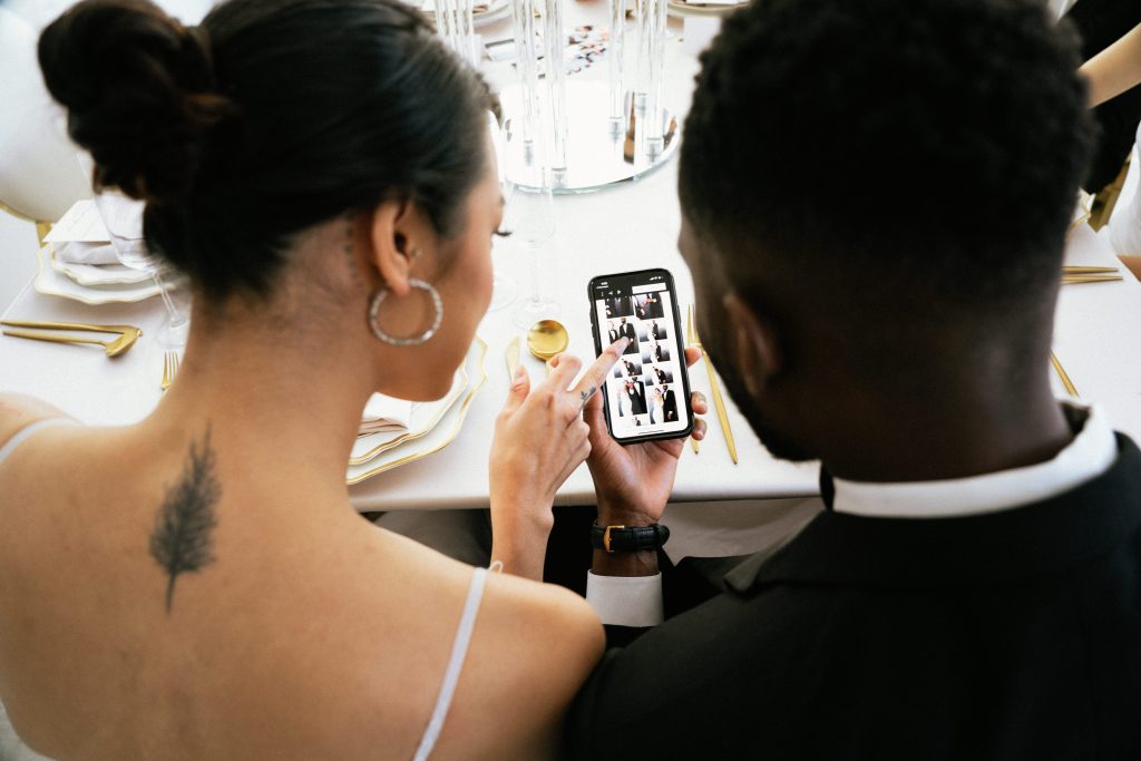 Couple looking at pictures from a photo booth on their phone