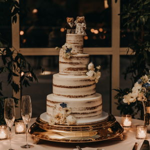 Statement 4-tier wedding cake with flowers, candles and champagne glasses